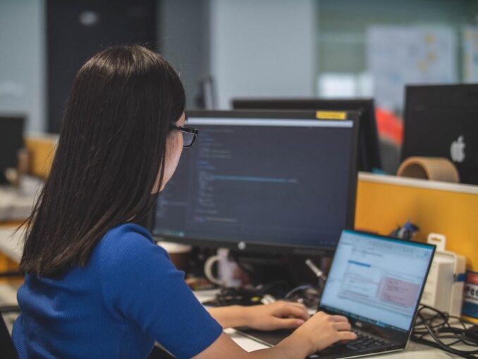 A woman in an office studying knowledge management tools on her computer