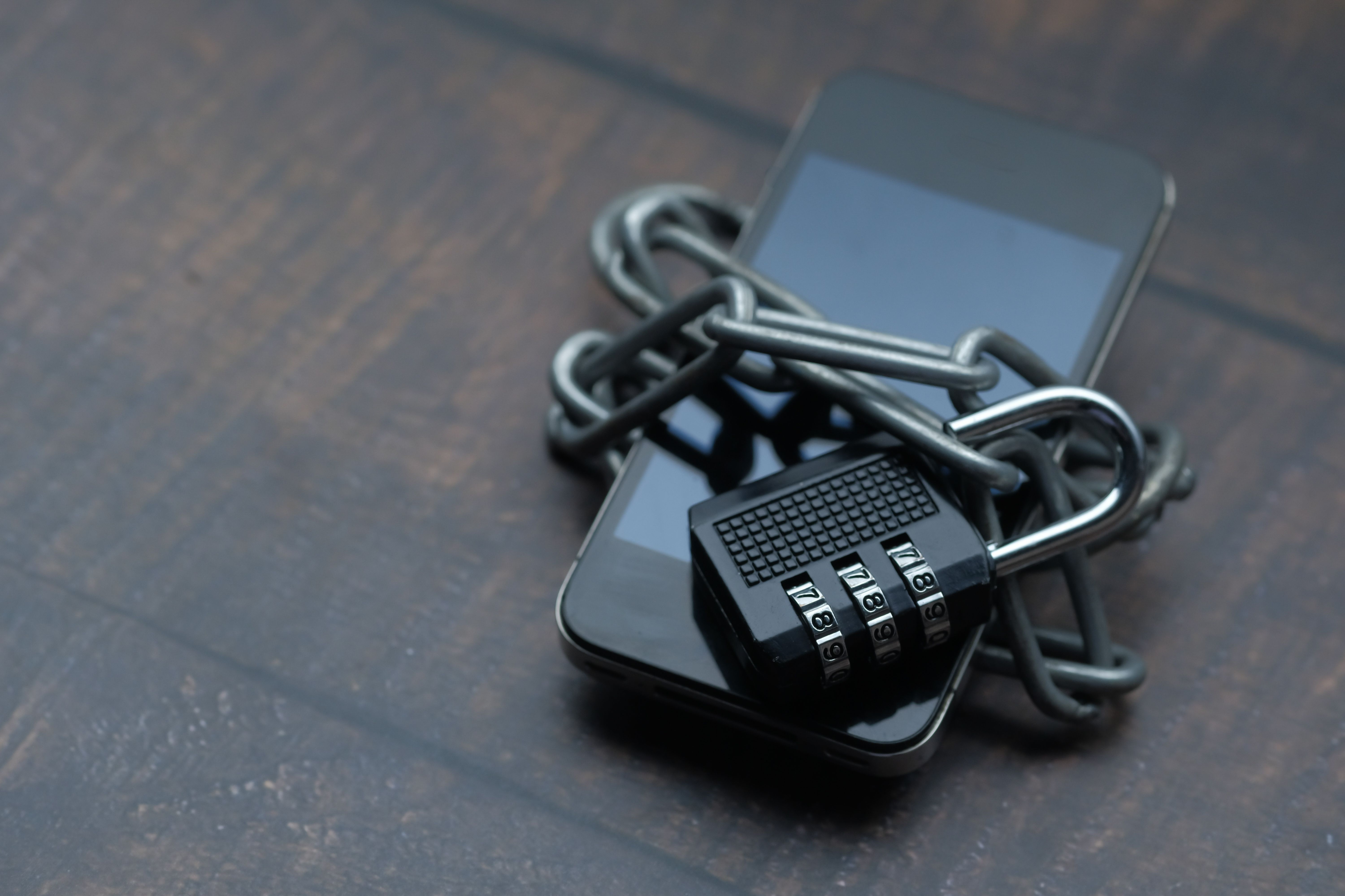 A smartphone secured with a chain and padlock, symbolizing protection of personal digital information.